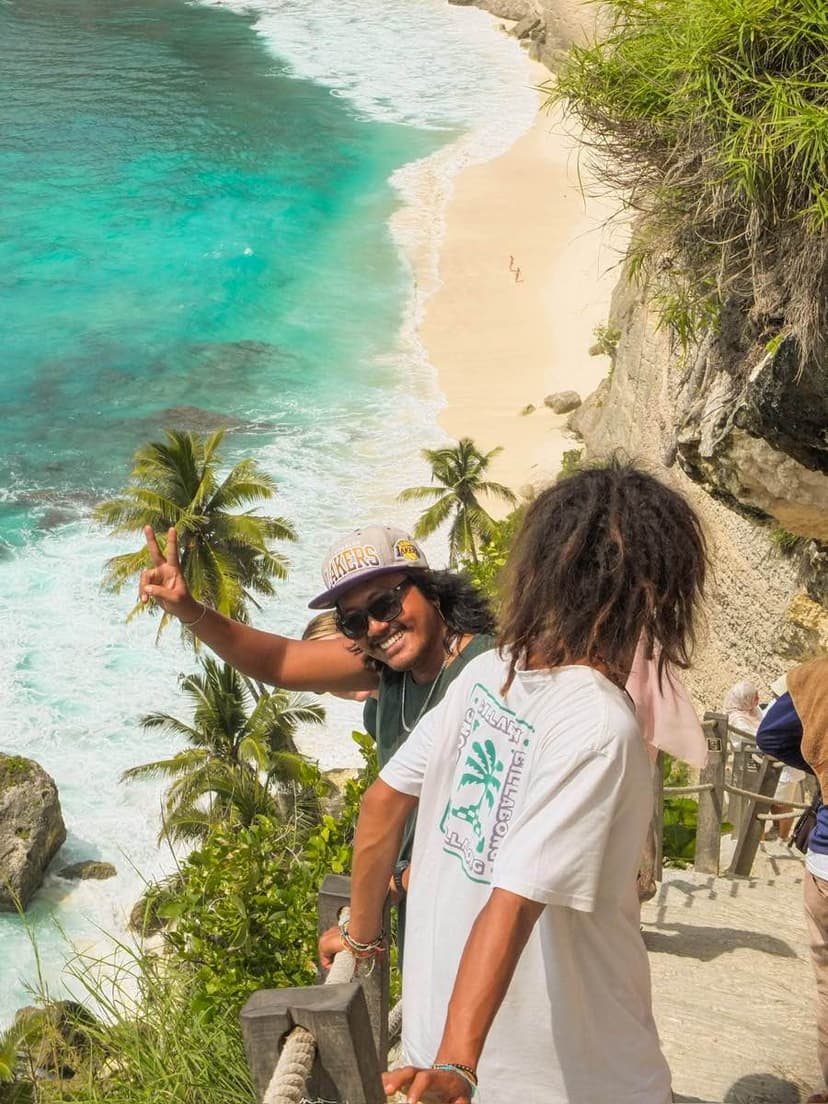 Travellers enjoying the stunning view over Diamond Beach in Nusa Penida, Bali. Diamond Beach is one of the most famous viewpoints on the island, known for its turquoise water, white sand, and dramatic limestone cliffs.