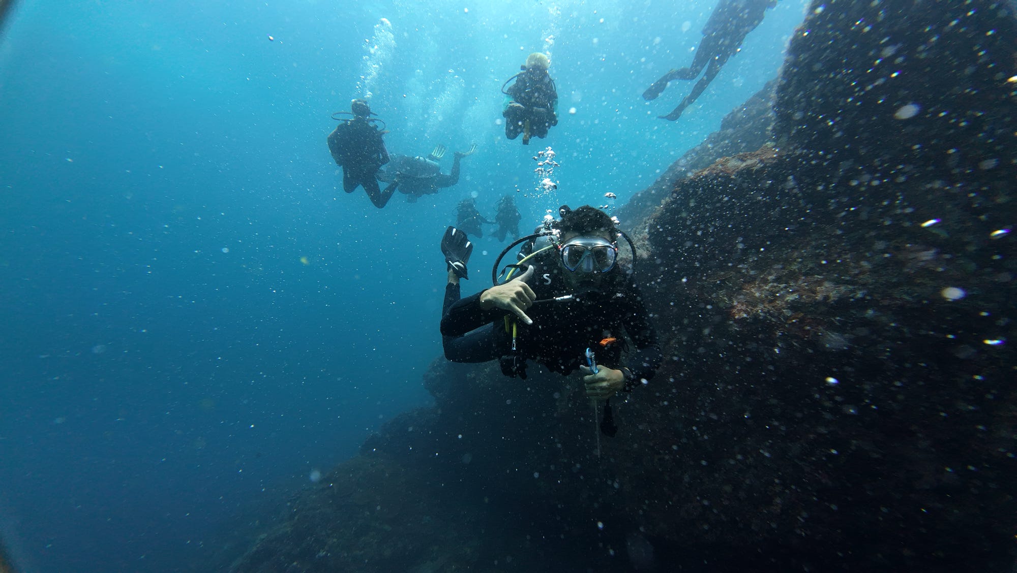 Scuba diver exploring clear blue water and reef life in Nusa Penida