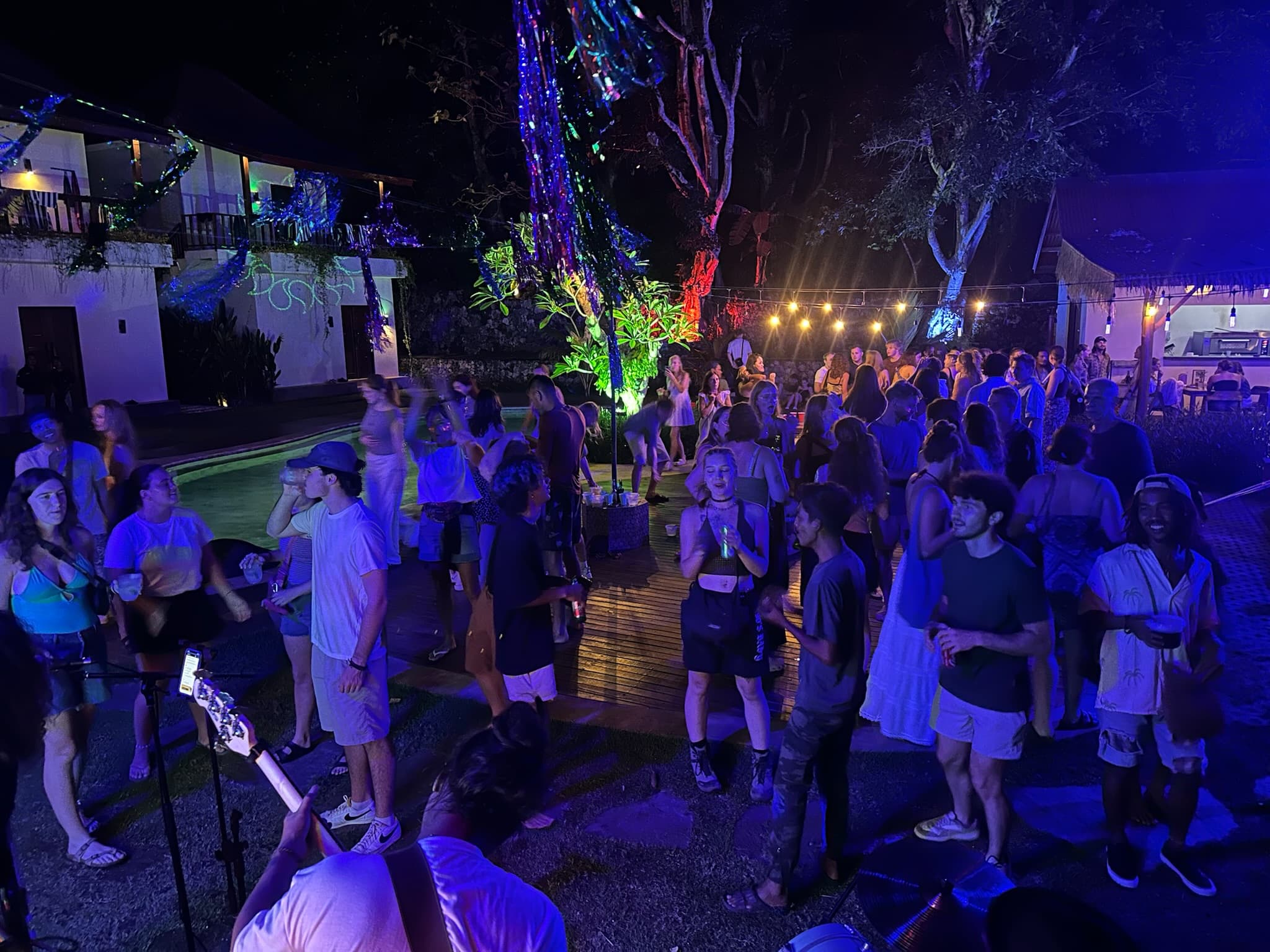 Guests filling the illuminated jungle dancefloor at The Penida Project Full Moon Party in Nusa Penida