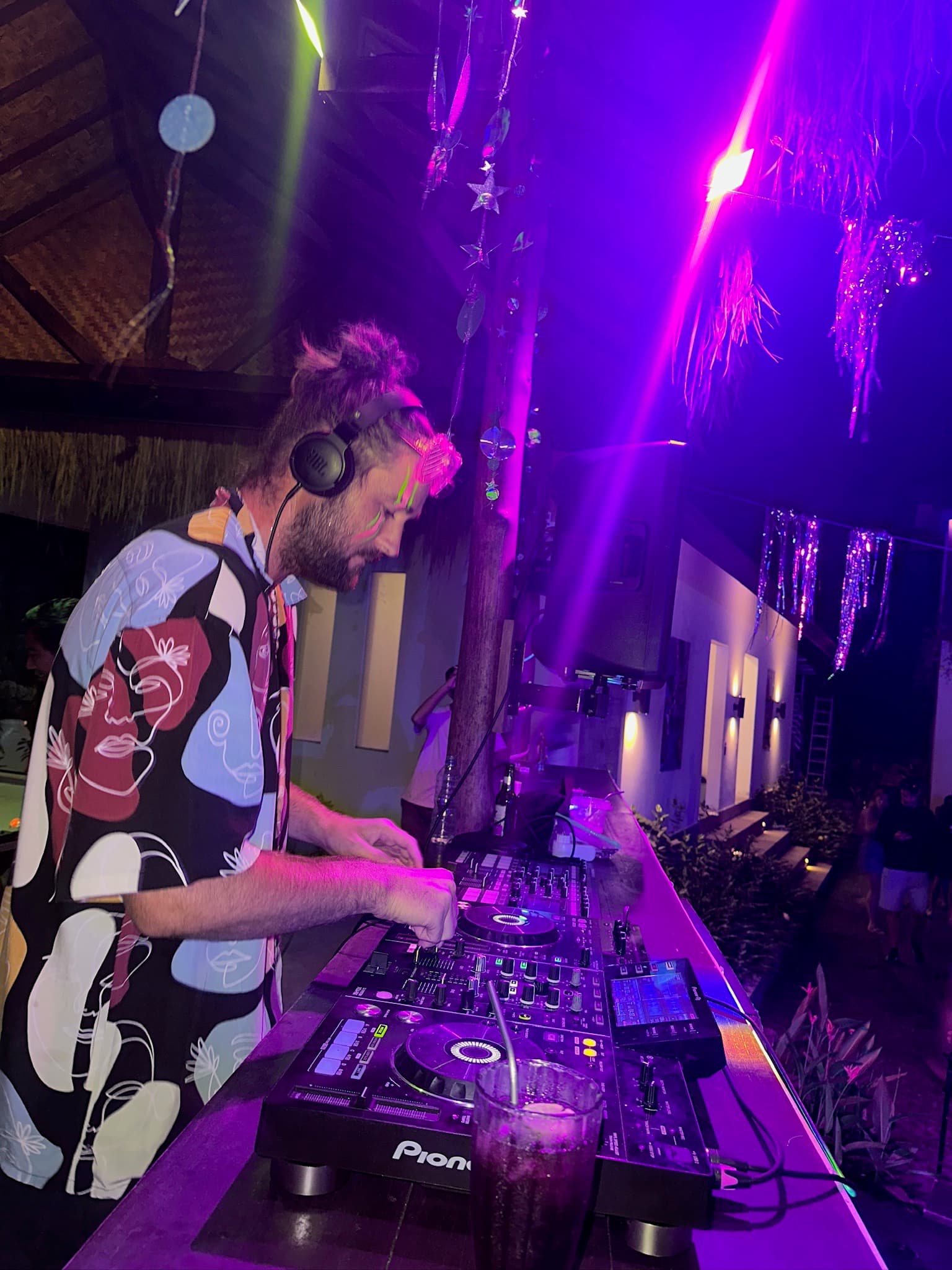 DJ performing beneath purple lights at The Penida Project Full Moon Party