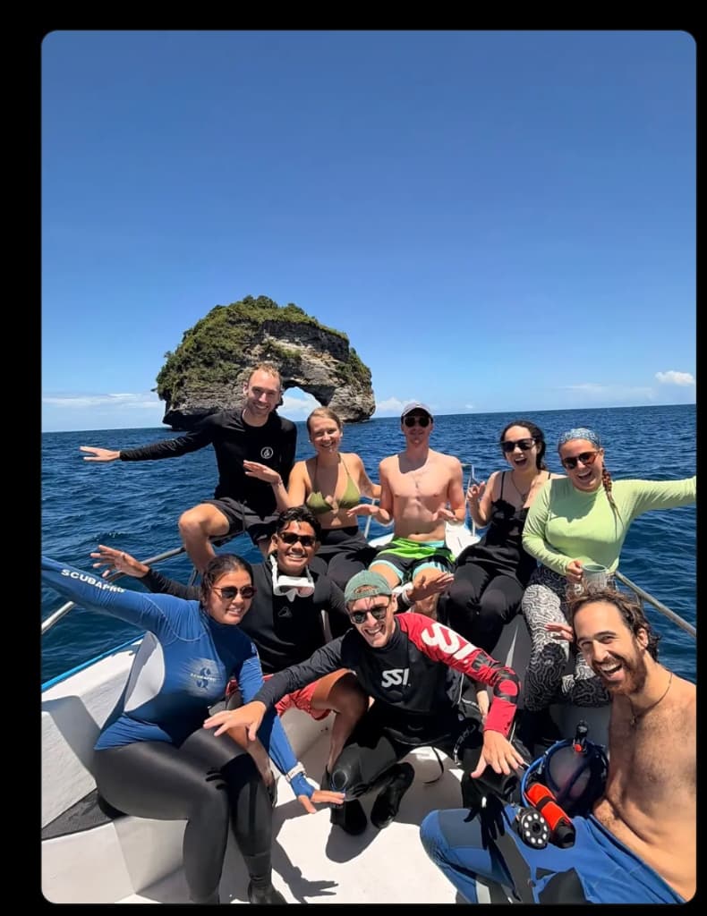 Project Laut divers and guests smiling together on a Nusa Penida dive boat