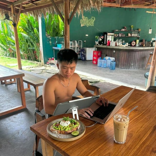 Digital nomad working with coffee and breakfast at The Penida Project in Nusa Penida