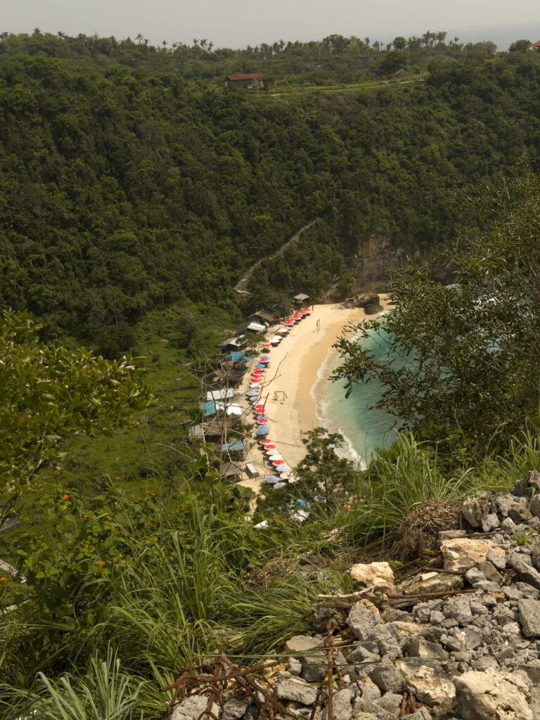 View of Atuh Beach in Nusa Penida Bali from the cliff viewpoint with white sand and turquoise water