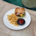 Beef smash burger with melted cheese, lettuce, tomato and crinkle-cut fries at The Penida Project in Nusa Penida.