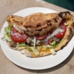 Falafel pita with lettuce, eggplant, tomato, pickled cabbage, hummus and yogurt mint sauce at The Penida Project in Nusa Penida