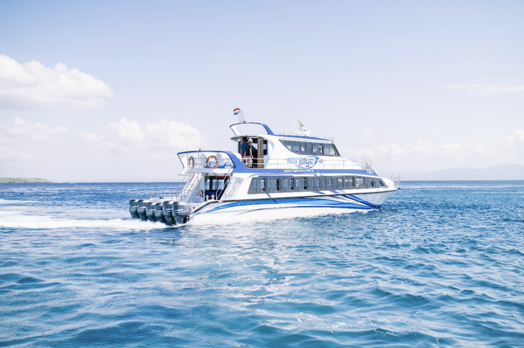 Fast boat cruising across calm blue waters from Bali to Nusa Penida