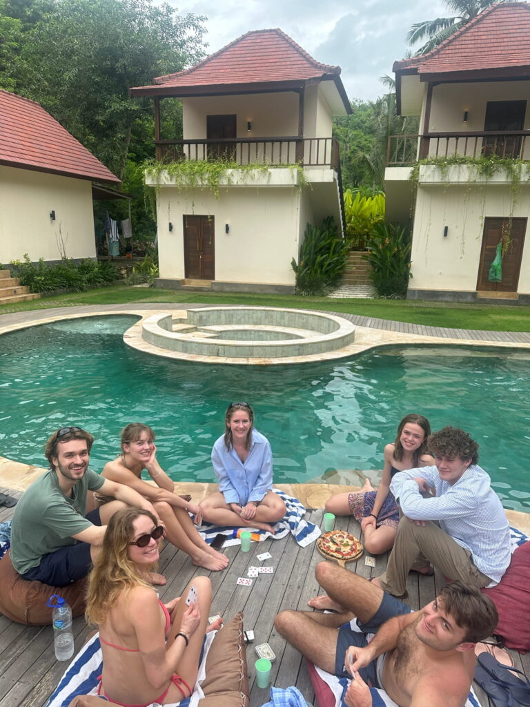 Travellers relaxing by the pool at The Penida Project luxury hostel in Nusa Penida