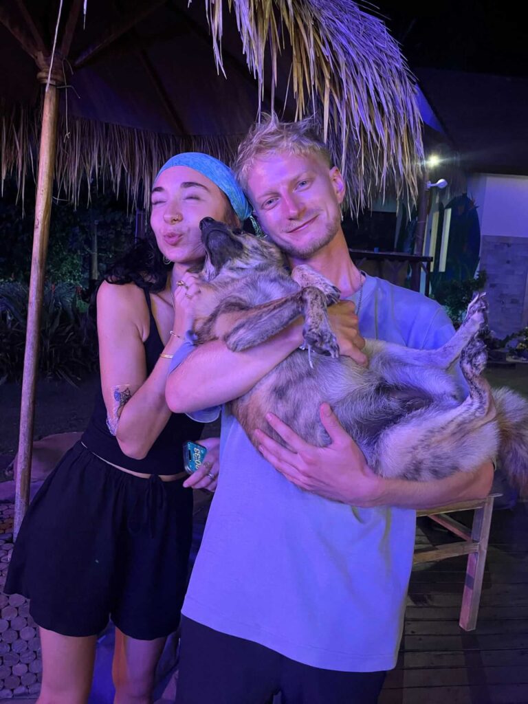 Travellers socialising with a dog at a hostel in Nusa Penida